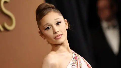 Getty Images Ariana Grande posing on the Oscars red carpet